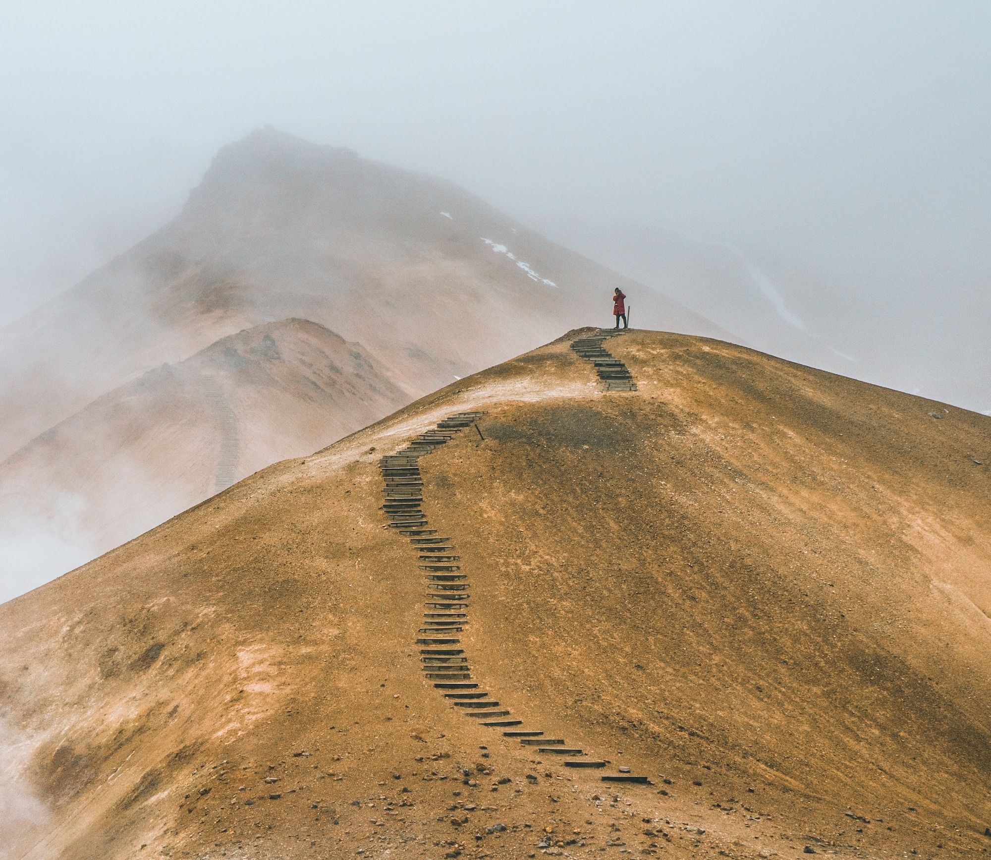 man on top brown hill