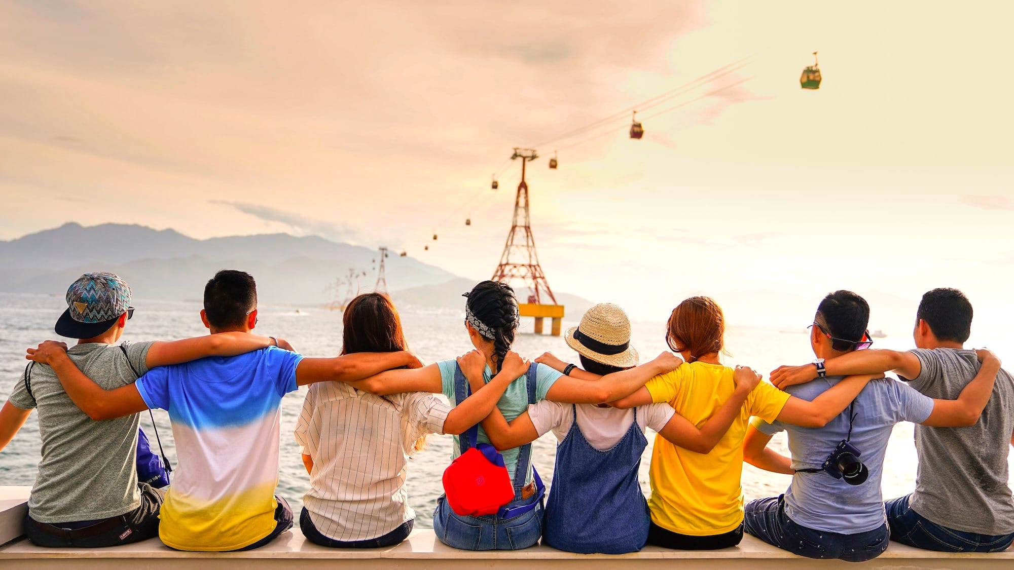 people holding shoulders sitting on wall