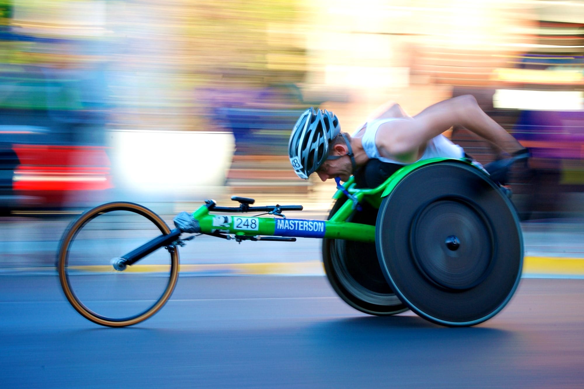 man riding green racing wheelchair